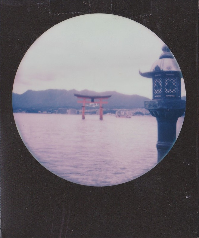 Torii of Itsukushima standing in water.